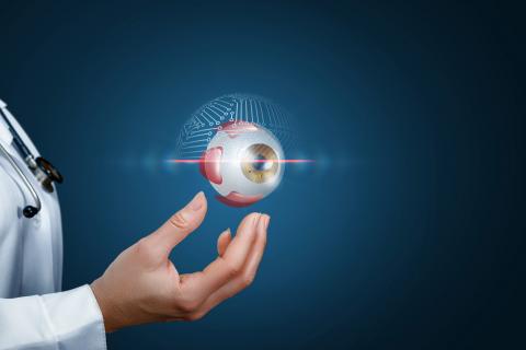 a man's hand with depiction of a human eyeball floating on top